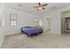 Large bedroom with carpet, ceiling fan, windows, and an ensuite bathroom at 15469 W Dreyfus St, Surprise, AZ 85379