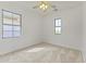 Minimalist bedroom with carpet, ceiling fan and two windows, offering bright, natural light at 15469 W Dreyfus St, Surprise, AZ 85379