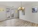 Light-filled dining area featuring hardwood flooring and access to the backyard through double doors at 15469 W Dreyfus St, Surprise, AZ 85379