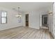 Spacious dining room featuring wood floors, natural light, and modern chandelier at 15469 W Dreyfus St, Surprise, AZ 85379