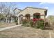 Inviting single-story home featuring an appealing front porch and red flowers, adding charm to its facade at 15469 W Dreyfus St, Surprise, AZ 85379