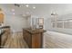 Open concept kitchen with granite counters, island, fireplace and light wood floors at 15469 W Dreyfus St, Surprise, AZ 85379