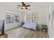 Bright living room featuring hardwood floors, a ceiling fan, and large windows for natural lighting at 15469 W Dreyfus St, Surprise, AZ 85379