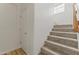 Carpeted staircase with a door and light wood floors at the base of the stairs at 15469 W Dreyfus St, Surprise, AZ 85379