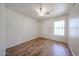 Bright bedroom with wood-look floors, ceiling fan, and natural light from a window at 16640 W Polk St, Goodyear, AZ 85338