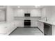 Bright white kitchen featuring modern stainless steel appliances, white cabinets and quartz countertops at 18060 N 24Th Dr, Phoenix, AZ 85023