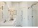 Well-lit bathroom with double sinks, white countertop, framed mirrors, modern sconces, and a glass-enclosed shower enhancing the space at 20301 W Turney Ave, Buckeye, AZ 85396