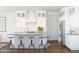 Bright kitchen featuring an island with seating, modern lighting, stainless steel appliances, and white cabinetry at 20301 W Turney Ave, Buckeye, AZ 85396