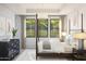 Sunlit primary bedroom with a four-poster bed, patterned wallpaper, black framed windows, and neutral curtains creating a calming retreat at 20301 W Turney Ave, Buckeye, AZ 85396