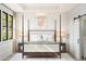 Bright primary bedroom features a four-poster bed, decorative bedside lamps, ensuite bathroom with sliding door, and white paneled walls at 20301 W Turney Ave, Buckeye, AZ 85396