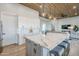 Bright kitchen featuring a large island with marble countertop, white cabinets and seating adjacent to the living area at 2040 W Gail Rd, Queen Creek, AZ 85142