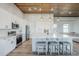 Well-lit kitchen featuring an island with seating, white cabinets, stainless steel appliances and modern fixtures at 2040 W Gail Rd, Queen Creek, AZ 85142