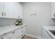 Bright laundry room with white cabinets, marble countertops, and plenty of storage space at 2040 W Gail Rd, Queen Creek, AZ 85142