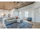 Open floor plan with a living room leading to a modern kitchen, all under a stylish wood-paneled ceiling at 2040 W Gail Rd, Queen Creek, AZ 85142