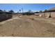 Large, empty backyard with dirt and some materials. The lot is fully fenced at 2205 W Hadley St, Phoenix, AZ 85009