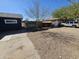 Gravel driveway featuring advertising signage and a vehicle parked on the right at 2205 W Hadley St, Phoenix, AZ 85009
