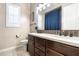 This bathroom features a dual sink vanity with dark wood cabinets, white countertop and a window at 22410 N 29Th Pl, Phoenix, AZ 85050
