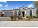Exterior of home with mature desert landscaping, stone accents, arched entryway, and a two-car garage at 22410 N 29Th Pl, Phoenix, AZ 85050