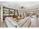 Bright living room showcasing built-in shelves, ceiling fan, large white sofa and access to outdoor patio at 22410 N 29Th Pl, Phoenix, AZ 85050