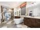Luxurious main bathroom with soaking tub, glass enclosed shower, dual vanities, and decorative tile flooring at 22410 N 29Th Pl, Phoenix, AZ 85050