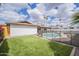 Landscaped backyard with artificial grass and a secure pool fence at 2254 S Noche De Paz --, Mesa, AZ 85202