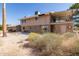 Wide shot of a backyard showing a two-story home with a balcony and desert vegetation at 27002 N 64Th St, Scottsdale, AZ 85266