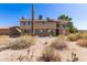 Expansive backyard featuring a two-story home with a balcony overlooking desert vegetation at 27002 N 64Th St, Scottsdale, AZ 85266