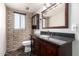 Bathroom with brick wall and dark wood vanity at 27002 N 64Th St, Scottsdale, AZ 85266
