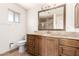 Bathroom features a brown vanity with granite countertop and a framed mirror at 27002 N 64Th St, Scottsdale, AZ 85266