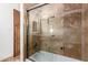 Shower with beige tile surround, glass door, and built-in storage niche at 27002 N 64Th St, Scottsdale, AZ 85266