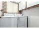 Laundry room featuring a stacked washer and dryer unit with overhead cabinets at 27002 N 64Th St, Scottsdale, AZ 85266