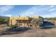 Tan home with rustic wooden beams and desert landscaping against a backdrop of a clear blue sky at 28619 N 152Nd St, Scottsdale, AZ 85262