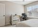 Serene bedroom with a mirrored dresser, a modern desk, and a bright window with blinds at 29243 N 122Nd Ln, Peoria, AZ 85383