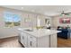 Kitchen island with barstool seating, sink, and stainless dishwasher, with an open view to the living room at 29243 N 122Nd Ln, Peoria, AZ 85383