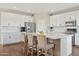 Well-lit kitchen with a large island, white cabinets, stainless steel appliances, and a breakfast bar at 29243 N 122Nd Ln, Peoria, AZ 85383