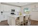 Bright kitchen with white cabinets, quartz countertops, stainless appliances, and a breakfast bar with seating at 29243 N 122Nd Ln, Peoria, AZ 85383