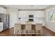 Bright kitchen features white cabinetry, a stainless steel refrigerator, and white quartz countertops at 29243 N 122Nd Ln, Peoria, AZ 85383