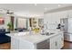 Open-concept kitchen with stainless steel appliances, white cabinets, and a view into the living area at 29243 N 122Nd Ln, Peoria, AZ 85383