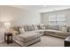 Spacious living room featuring a large sectional sofa with decorative pillows and modern decor at 29243 N 122Nd Ln, Peoria, AZ 85383
