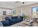 Open living area with a plush blue sofa, connecting seamlessly to the kitchen with a breakfast bar at 29243 N 122Nd Ln, Peoria, AZ 85383