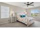 Bright primary bedroom with large windows, ceiling fan, and bedside lamps at 29243 N 122Nd Ln, Peoria, AZ 85383