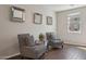 Sitting room features contemporary chairs, hardwood flooring, and bright lighting at 29243 N 122Nd Ln, Peoria, AZ 85383