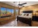 Spacious bedroom with a large window, a ceiling fan, and a comfortable king-size bed at 31912 N 141St St, Scottsdale, AZ 85262