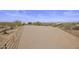Spacious equestrian arena surrounded by desert landscape and partial fencing provides ample riding space at 31912 N 141St St, Scottsdale, AZ 85262