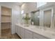 Elegant bathroom with double sinks, a large mirror, and access to a closet and tiled shower at 35231 N Danburite Ct, San Tan Valley, AZ 85144