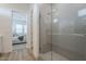 Modern bathroom with glass-enclosed shower, light tile, and view into bedroom creating a spa-like atmosphere at 35231 N Danburite Ct, San Tan Valley, AZ 85144