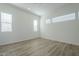 Spacious, sunlit bedroom with stylish wood-look floors and large windows at 35231 N Danburite Ct, San Tan Valley, AZ 85144