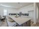 Large kitchen island with barstool seating and quartz countertops, next to a modern living area at 35231 N Danburite Ct, San Tan Valley, AZ 85144