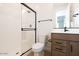 Modern bathroom featuring a glass-enclosed shower, toilet, and vanity with black fixtures and neutral color palette at 40234 N Alegre Dr, San Tan Valley, AZ 85140