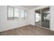 Bright bedroom features wood-look floors, large windows with blinds, and sliding glass door to backyard at 40234 N Alegre Dr, San Tan Valley, AZ 85140
